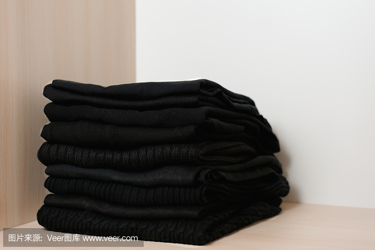 衣橱里黑色的针织毛衣。衣柜中的概念秩序。